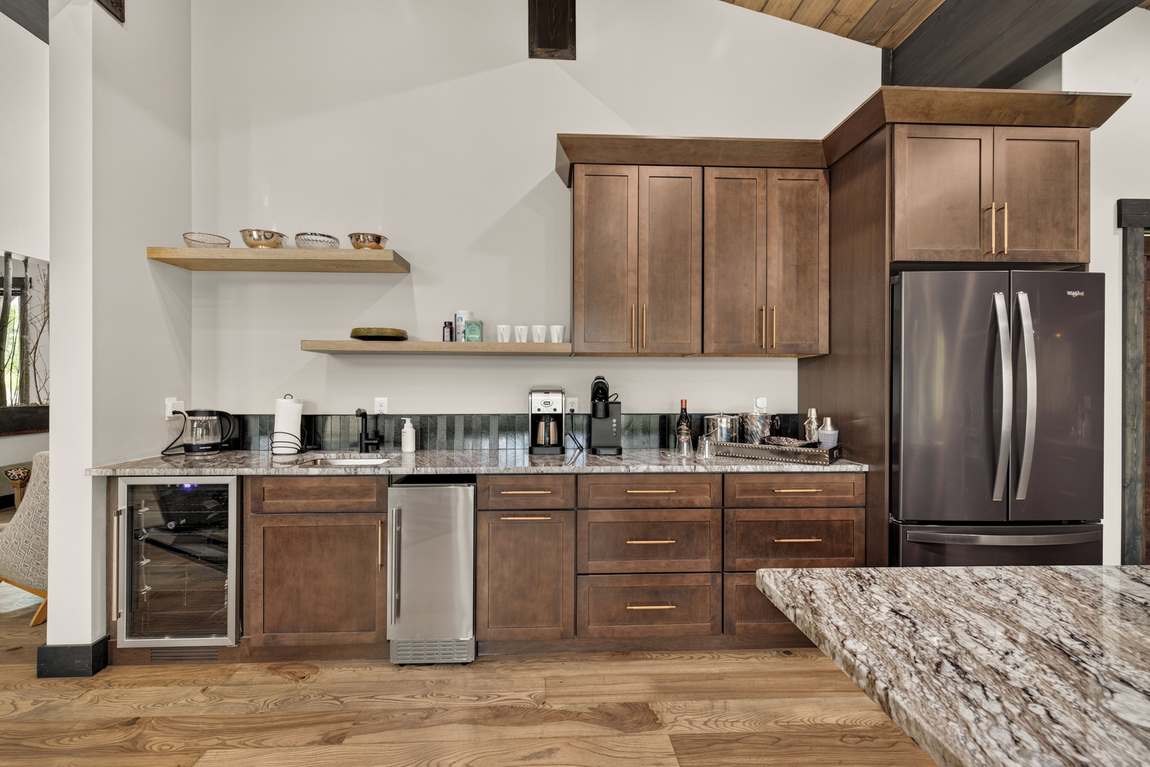 Une cuisine moderne avec des meubles en bois, des appareils en acier inoxydable et un plan de travail en marbre.