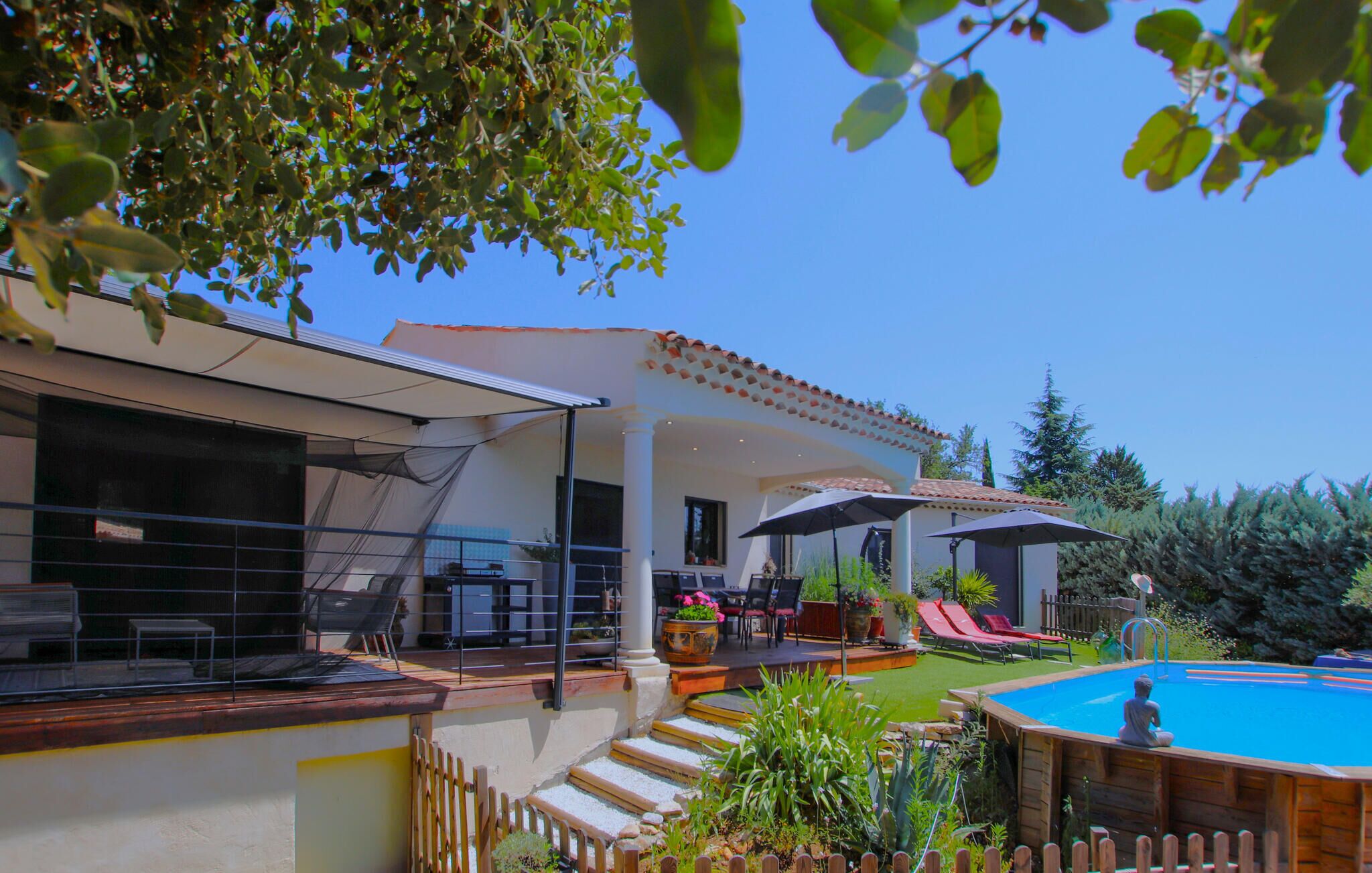 Ein Poolbereich mit Pool, Liegestühlen und einer Pergola.