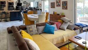Una sala de estar moderna con un sofá, una mesa de centro y un comedor con sillas.