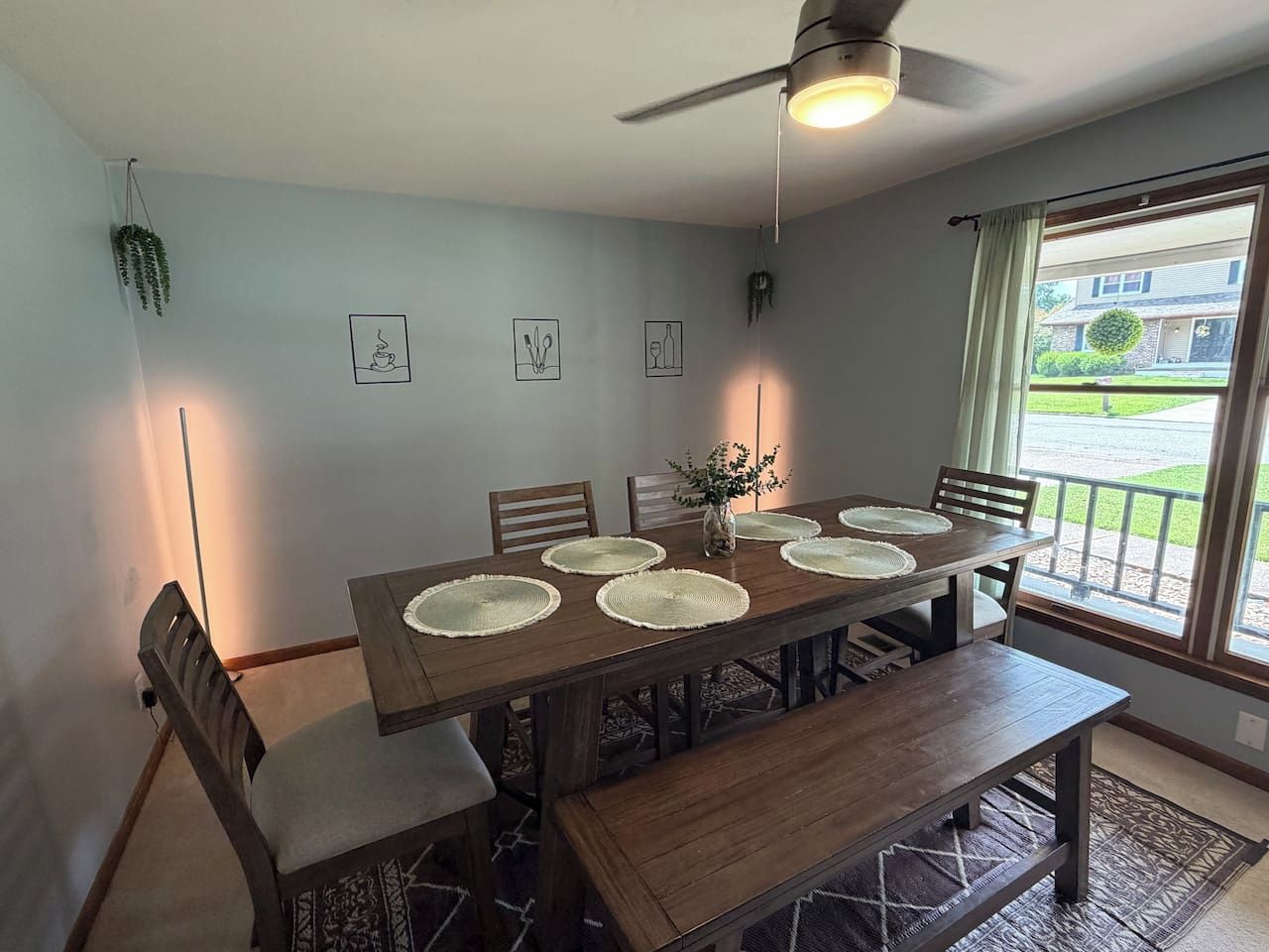 A dining area with a wooden table, chairs, and a ceiling fan.