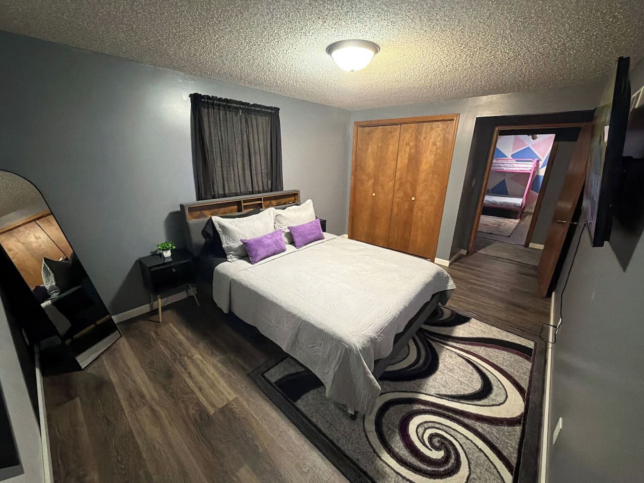 Une chambre à coucher avec un lit, une table de chevet et une armoire.