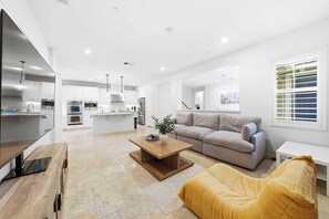 Ein modernes Wohnzimmer mit einer Couch, einem Couchtisch und einem Fernseher.