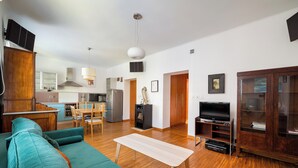 A living room with a sofa, a wooden coffee table, a TV, and a cabinet. - Nowy Świat Sunny Side Apartment (Warszawa)