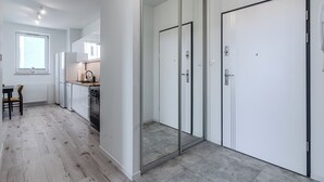 A modern kitchen with a dining area, a sliding glass door, and a white door.