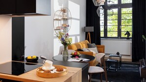 Eine moderne Küche mit Essbereich, einer Couch und Blick auf Grünfläche.