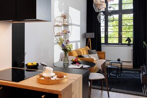 Eine moderne Küche mit Essbereich, einer Couch und Blick auf Grünfläche.