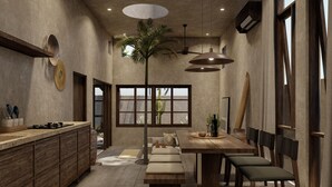 A modern kitchen with a central island, a dining area with a wooden table and benches, and a large window with a view. - Baia Villas Uluwatu (Pecatu)