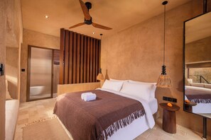 A hotel room with a bed, a ceiling fan, a large mirror, and a view of the outdoors. - Baia Villas Uluwatu (Pecatu)