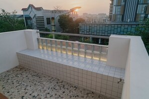 Varanda com soalho em azulejos e guarda-corpo.