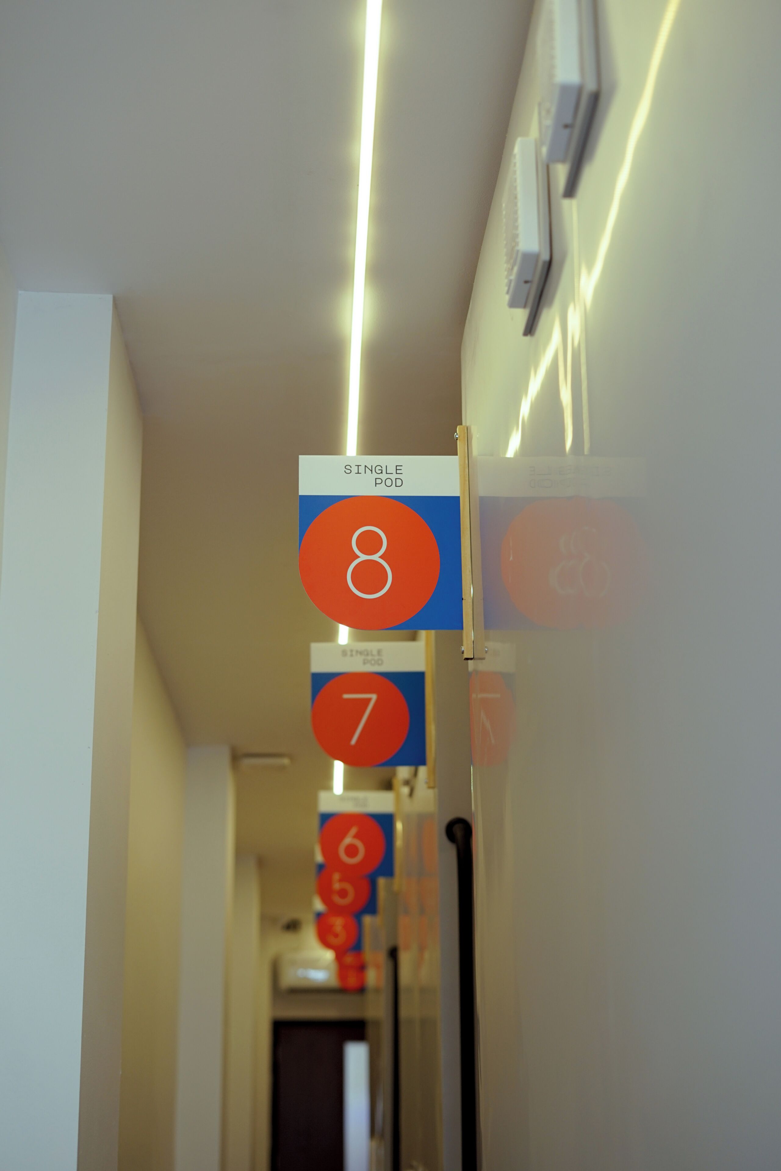 A hallway with numbered signs indicating room numbers 7, 8, and 6.