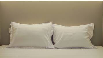 A bed with two pillows and a plain headboard.