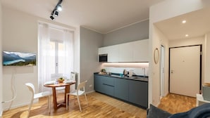 Une cuisine moderne avec un coin repas, un plancher en bois et une vue sur les montagnes par une fenêtre.