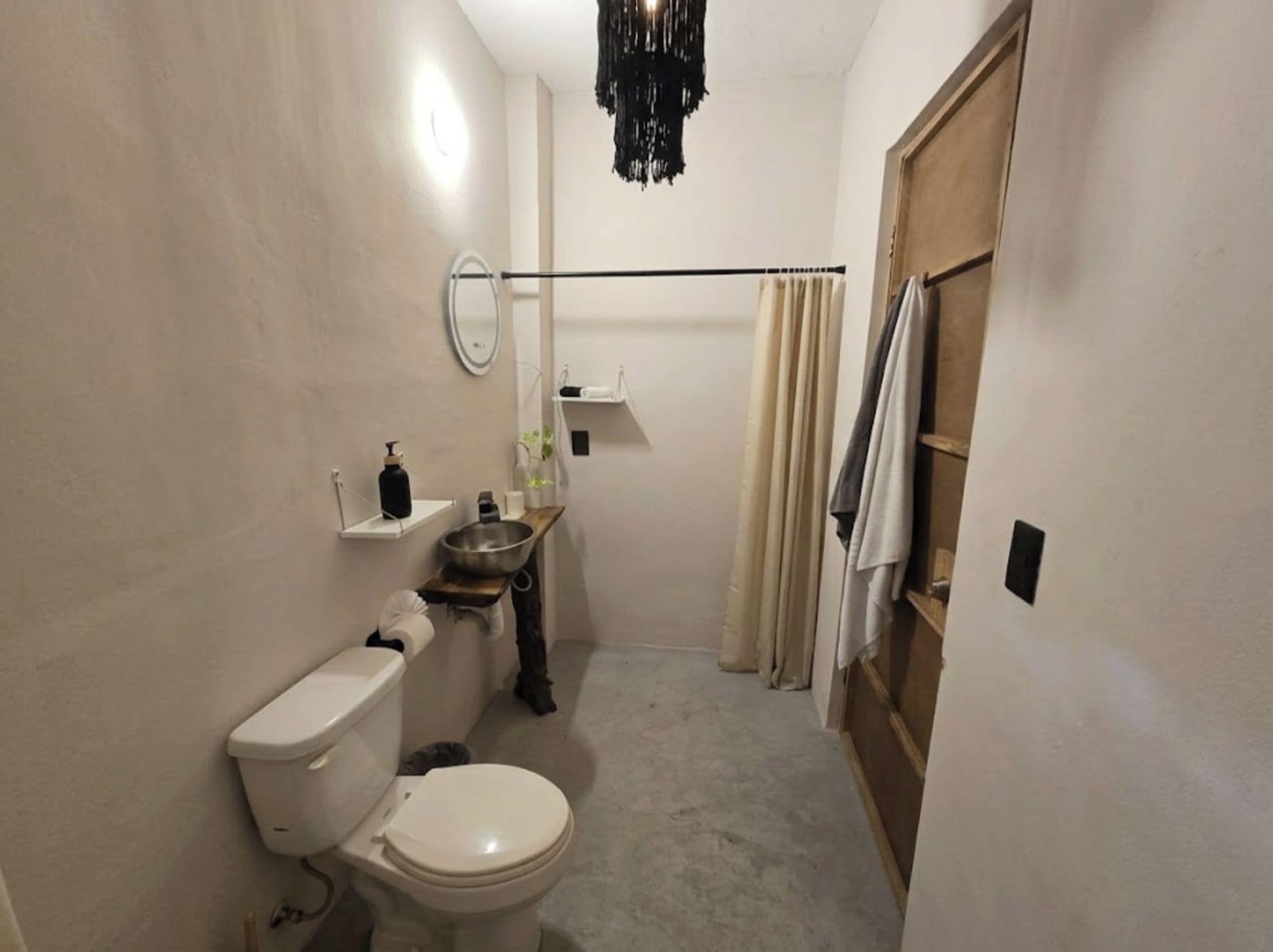 Un baño pequeño con inodoro, lavamanos y zona de ducha.