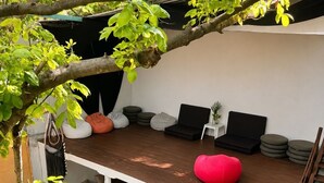 Un patio exterior con mobiliario, piscina y una escalera.