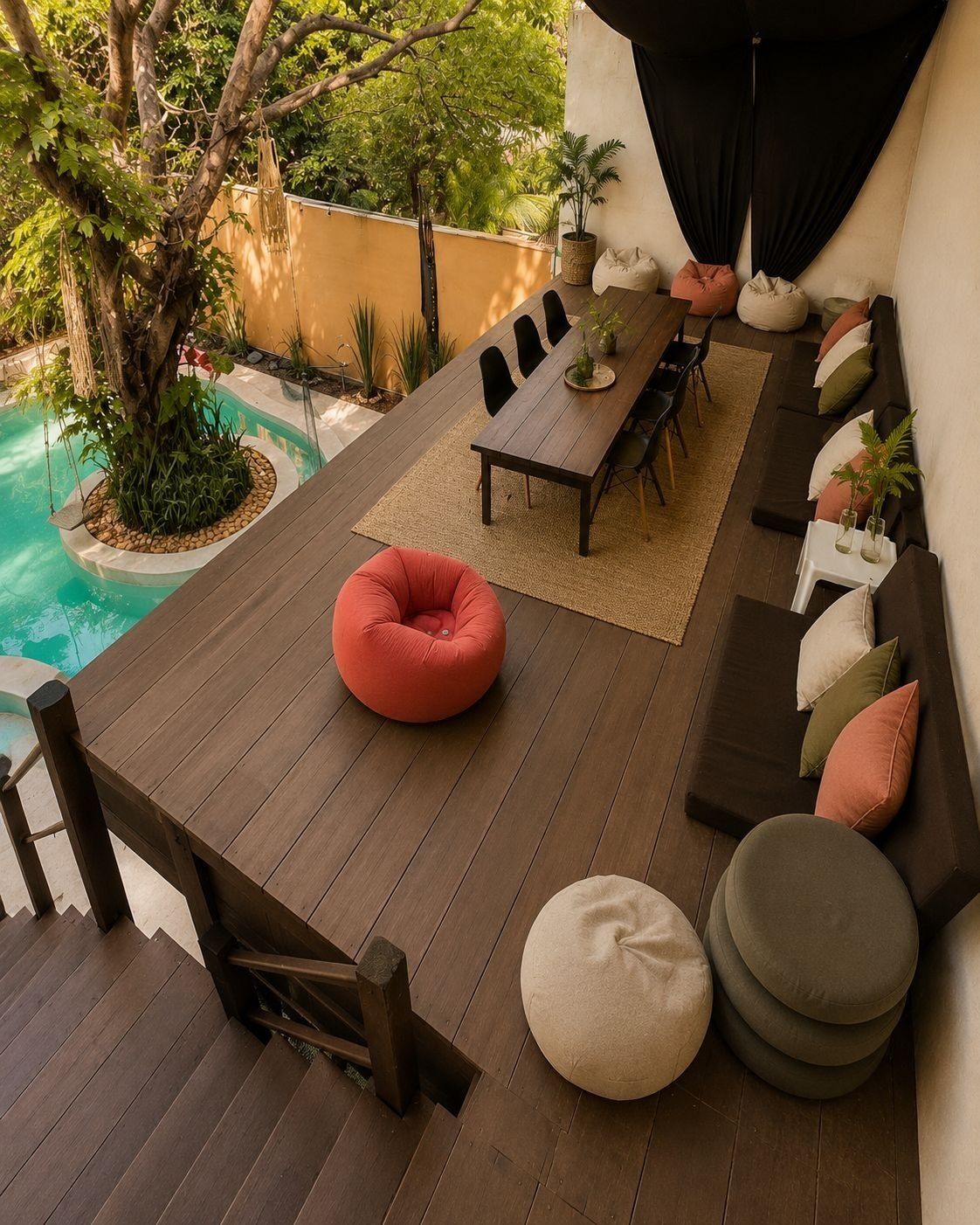 Una terraza de madera con una mesa de comedor, sillas y un sillón de peluche rojo.
