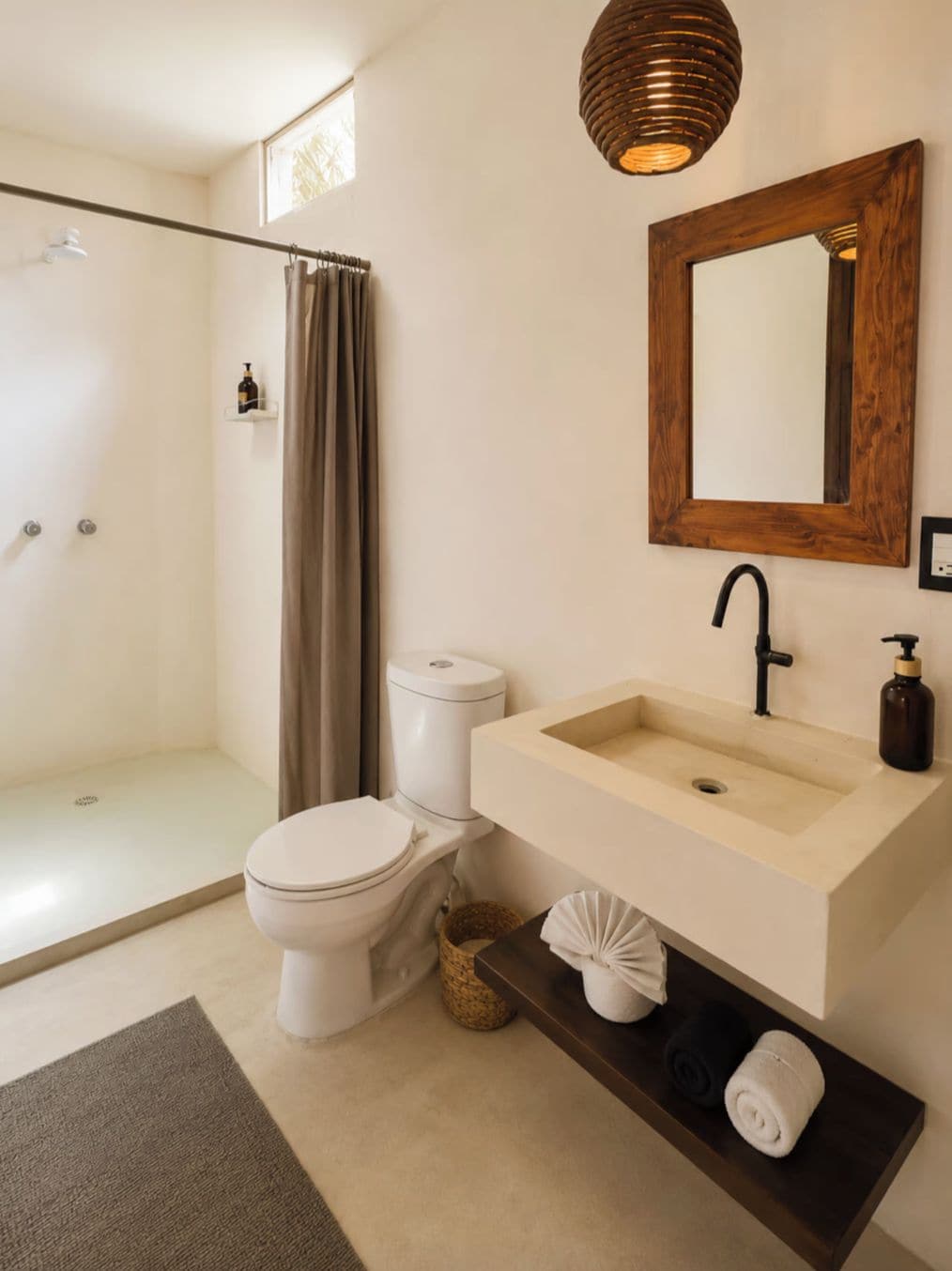 Un baño con inodoro, lavamanos y ducha.