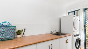 A kitchen with a washing machine, a sink, and a countertop. - The Sails 1/21 Beech Street  Evans Head (Evans Head)