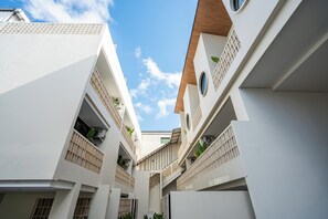 A modern building with multiple balconies, a central staircase, and a clear sky. - Salt Lofts Pererenan (Bali)