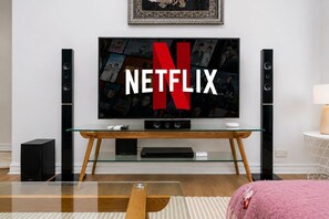 Entertainment setup with a large smart TV for streaming, flanked by tall speakers for an immersive sound experience. Set on a wooden stand with framed art above, it makes for cozy nights in.  - Havencrest 2BR Sydney CBD | Near Darling Harbour (Sydney)