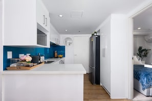 Start your day effortlessly in this 
bright, modern kitchen featuring a sleek blue backsplash, full-sized appliances, and a convenient coffee station just steps away from your cozy bedroom. 

 - Havencrest 2BR Sydney CBD | Near Darling Harbour (Sydney)