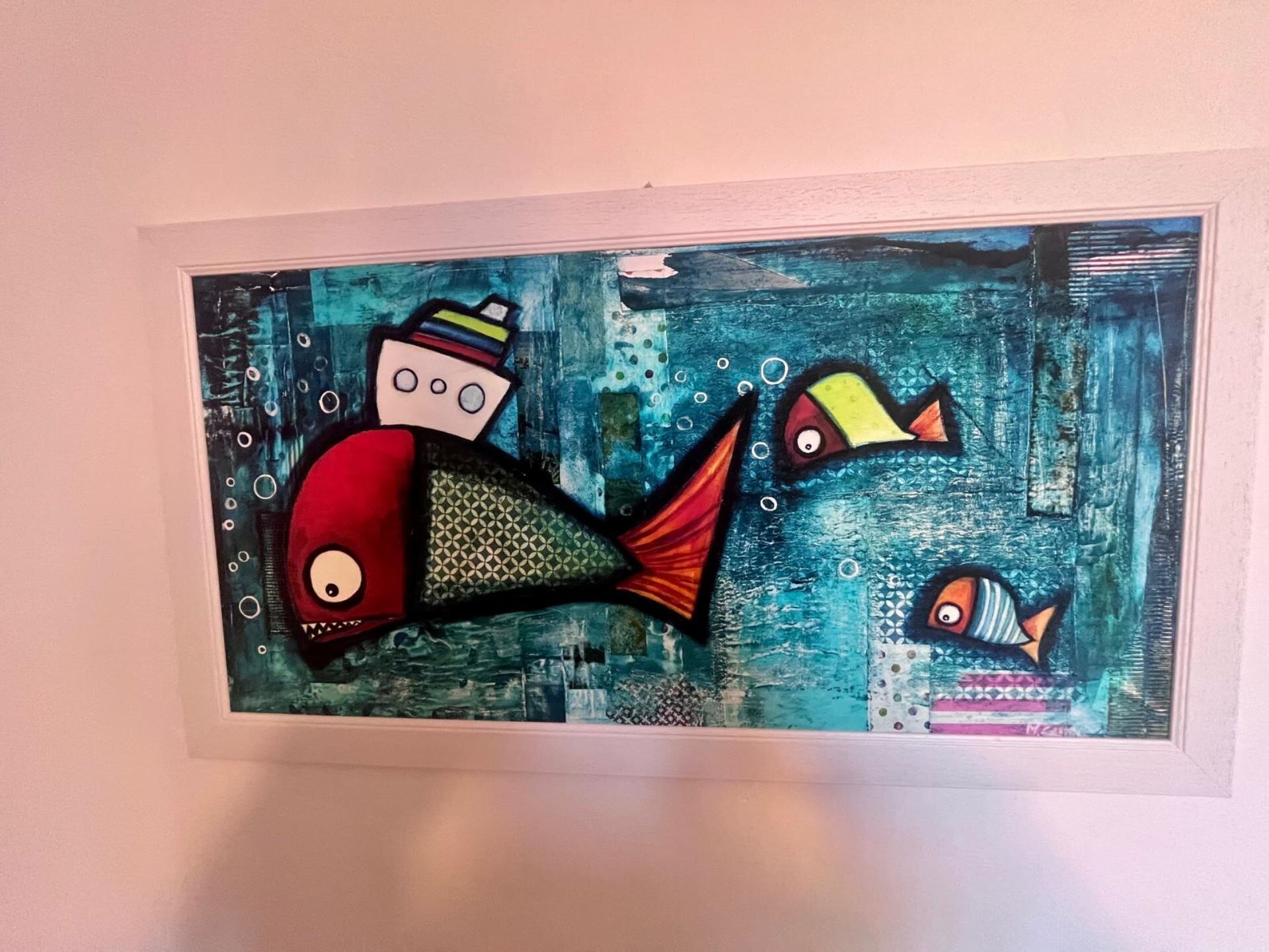 A framed artwork of a mermaid and fish on a textured blue background.