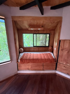 A wooden room with a bed, a window, and a wardrobe. - Beautiful 2 Story Dome Perfect for Your Getaway (Rivas)