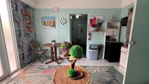 A compact kitchen with a dining area, a small table, and a chair. - Doña Lucía (Guánica)