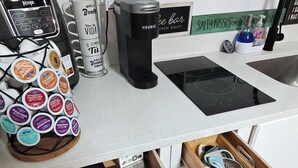 Keittiön työtasolla on kahvinkeitin, muki, vedenkeitin ja kahviautomaatti. Lisäksi siellä on näkyvillä myös keittiövälineitä ja mausteteline.