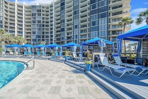 Um hotel com piscina, espreguiçadeiras e guarda-sóis.