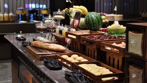 A buffet with various food items and a watermelon centerpiece.