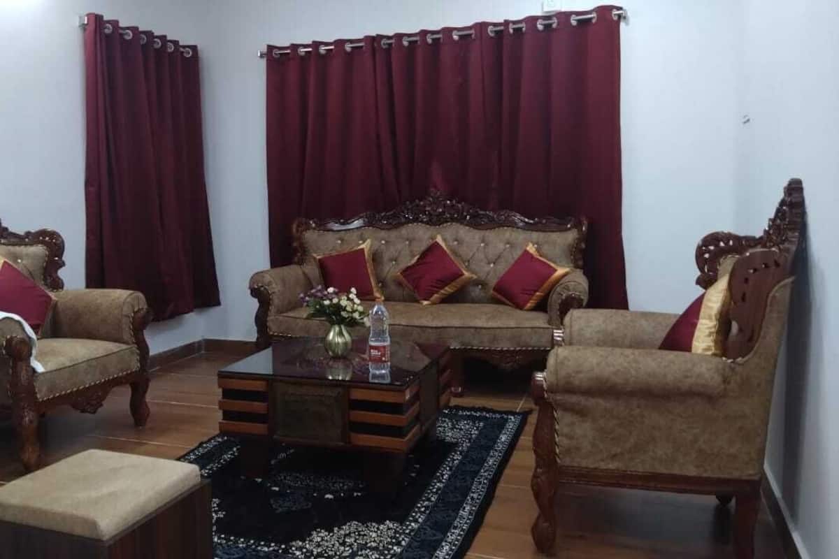 Uma sala de estar com um sofá, duas poltronas, uma mesa de centro e um tapete.
