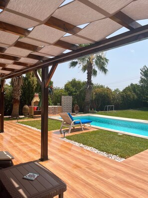 A covered outdoor area with a pool, lounge chairs, and a pergola structure. - Nature Villa · Pool · Large Garden · Cap Bon (Grombalia)