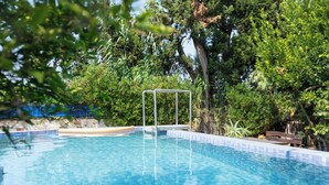 A swimming pool with a metal safety structure, surrounded by lush greenery. - Nature Villa · Pool · Large Garden · Cap Bon (Grombalia)