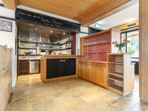 A kitchen with wooden cabinets, a chalkboard, and a refrigerator.