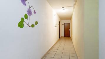 A hallway with a tiled floor and a wall with a floral mural.