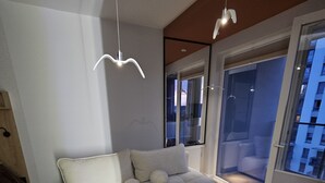 Una sala de estar moderna con sofá, piso de madera y vistas a través de una puerta de cristal.