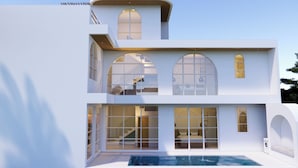 Ein modernes, zweistöckiges Haus mit Swimmingpool, großen Fenstern und einer Treppe.