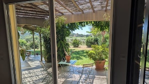 A patio with a table, chairs, and potted plants. - Large family home in the middle of an olive grove (Le Pradet)