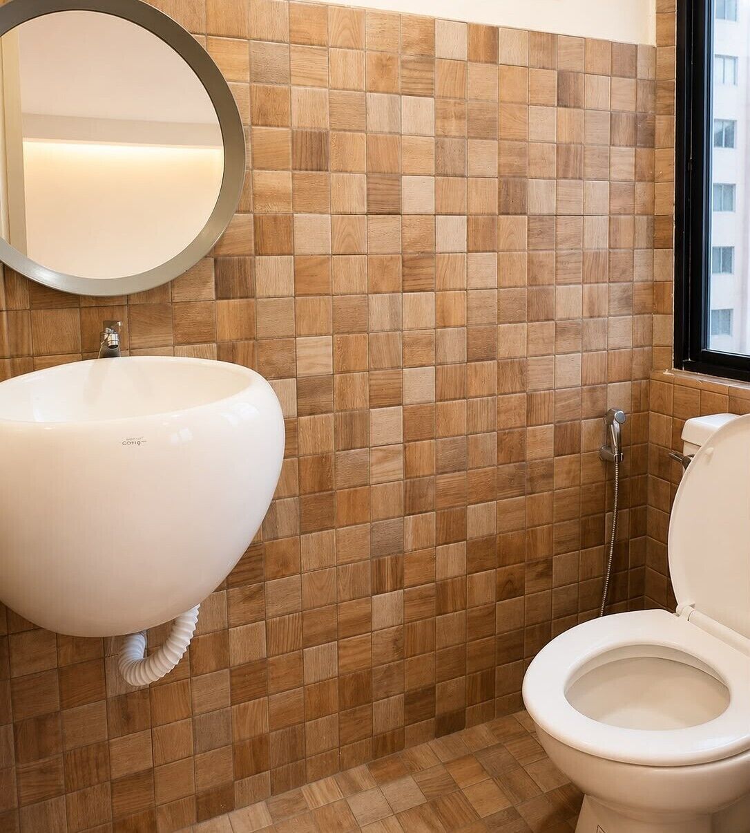 A bathroom with a white sink, a mirror, and a toilet.