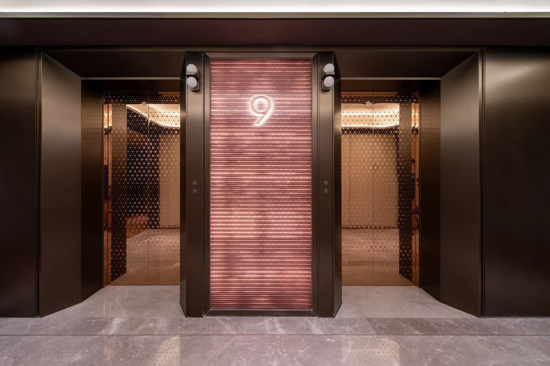 An elevator with a digital display showing the number 9, leading to a room with patterned walls and a bed.