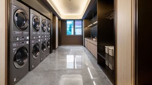 Une buanderie équipée de plusieurs machines à laver, une fenêtre offrant une belle vue et un espace cuisine moderne.