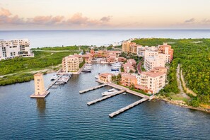 Un port de plaisance situé sur la côte, comprenant plusieurs bâtiments, des quais et des bateaux.