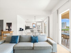 Un salon moderne comprenant un canapé, un coin repas et une cuisine.