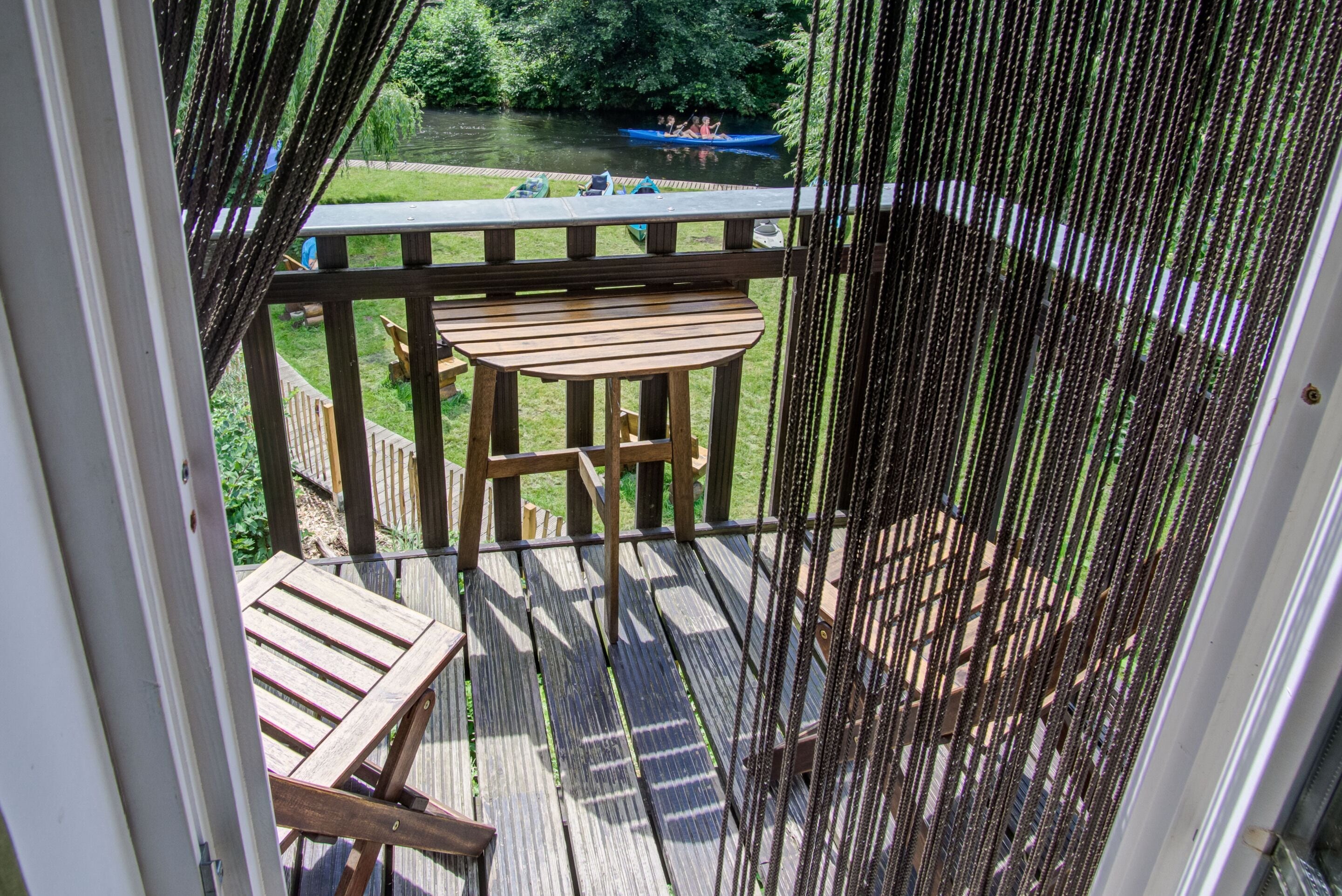 A wooden deck with a view of a river and a boat.