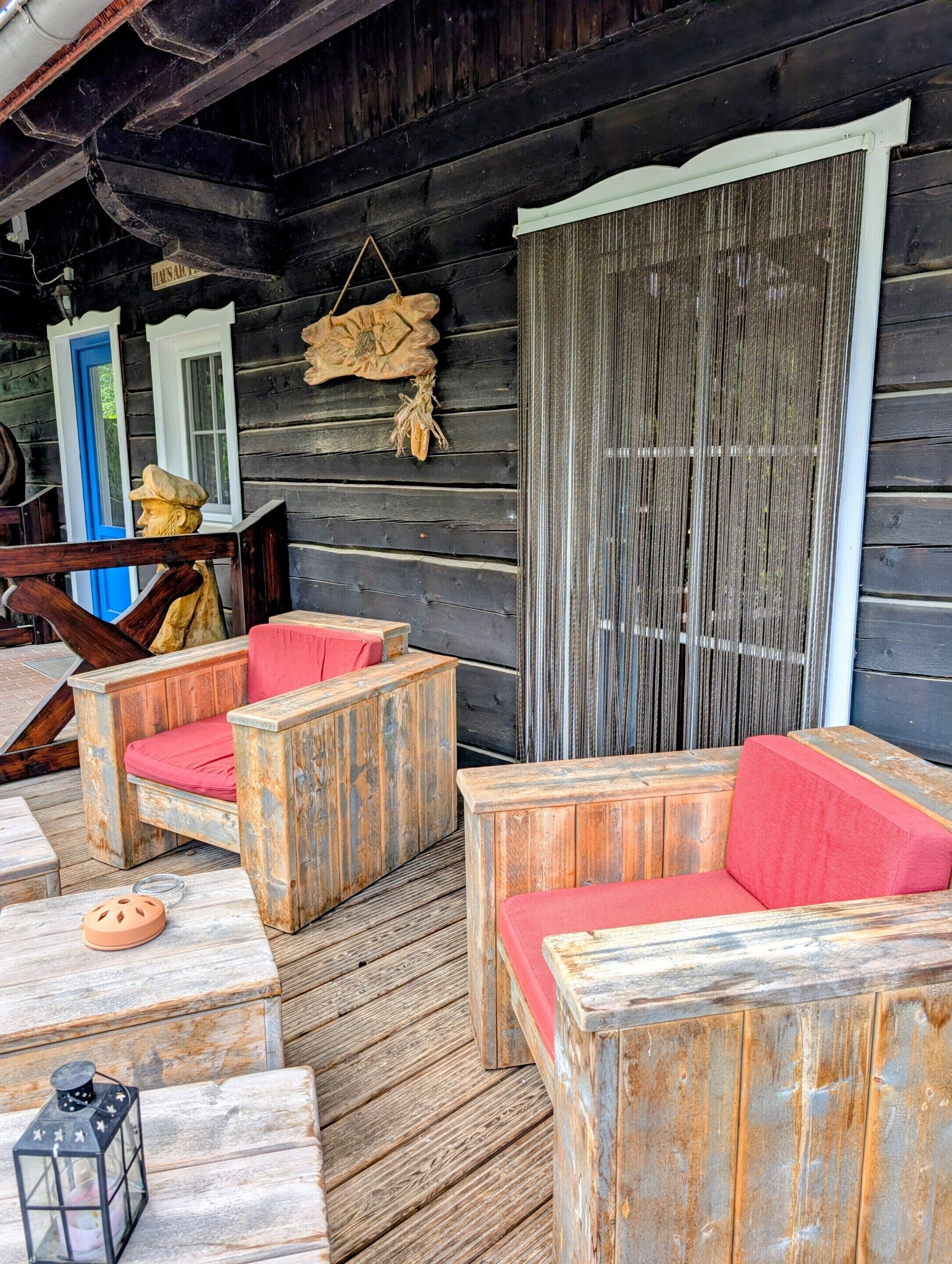 A rustic wooden deck with outdoor seating and a decorative lantern.