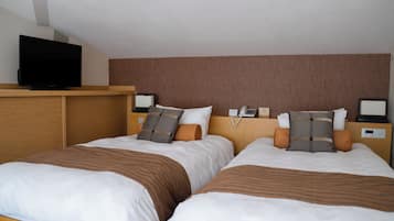 Habitación de hotel con dos camas, un televisor sobre un soporte y un cabecero con un teléfono y un reloj digital.