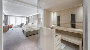 Una habitación de hotel moderna con cama, escritorio, silla y un espejo grande.