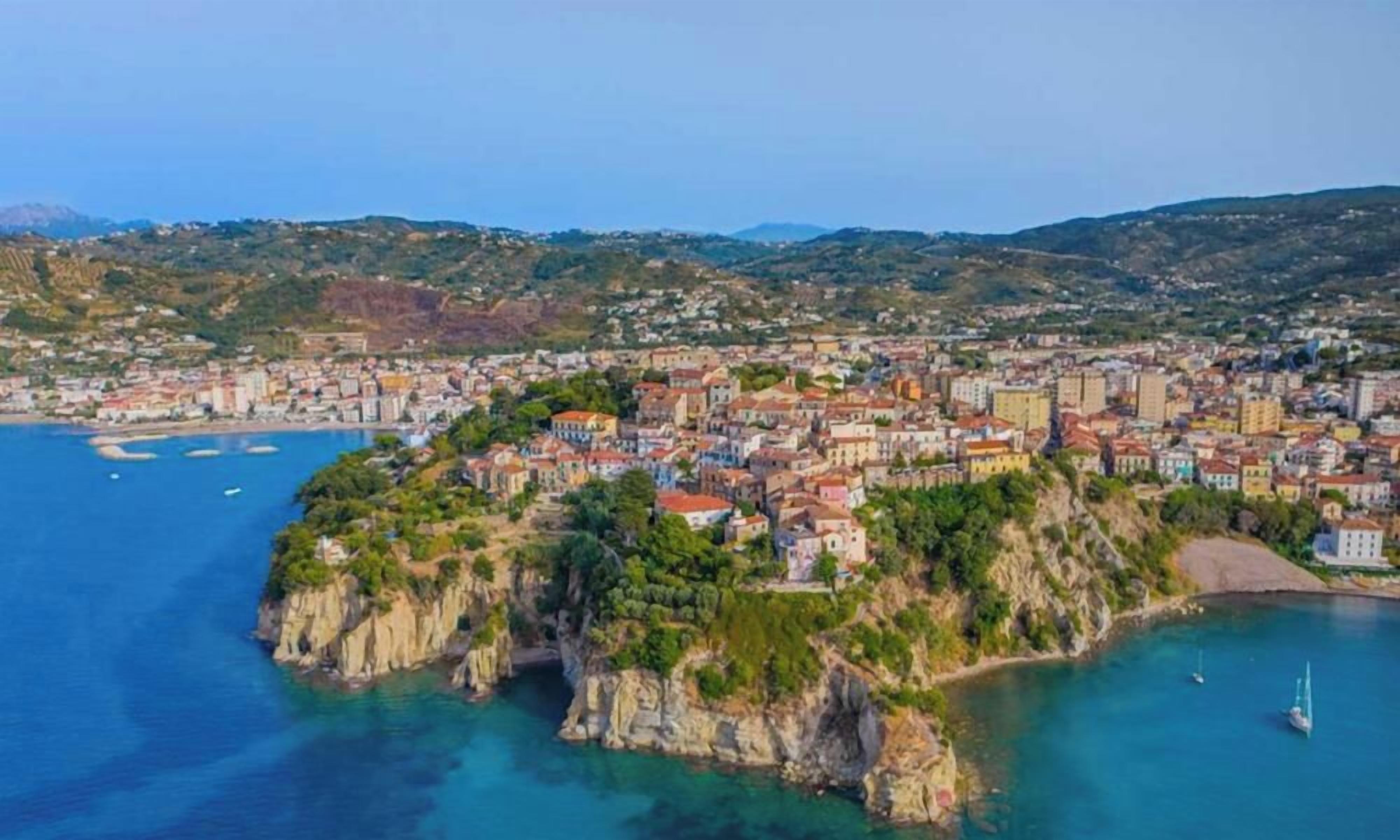 A coastal town with buildings on a cliff overlooking the sea.
