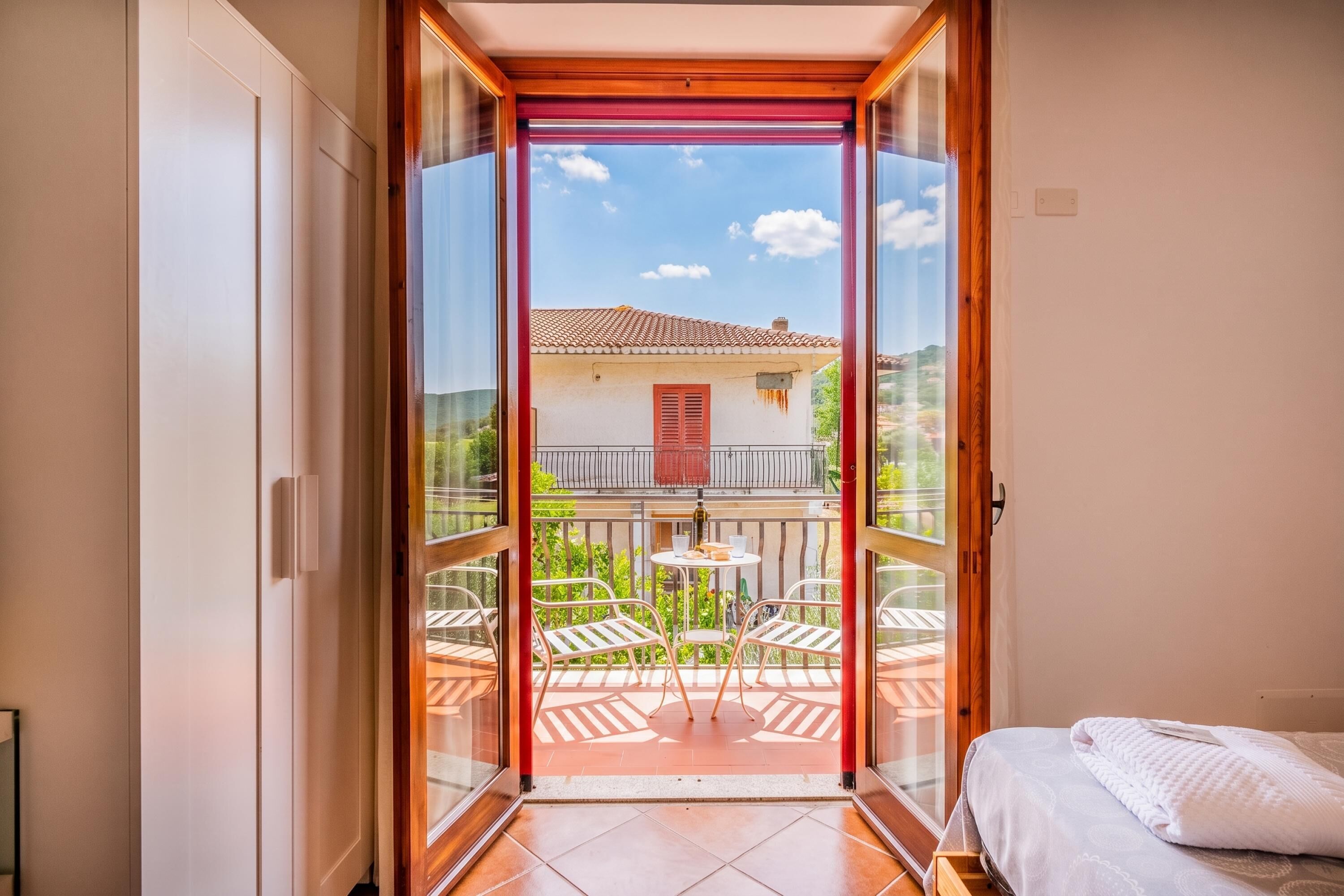 A room with a sliding glass door leading to an outdoor patio with a table and chairs.