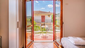 Una habitación con puerta corrediza de vidrio que da a un patio exterior con mesa y sillas.